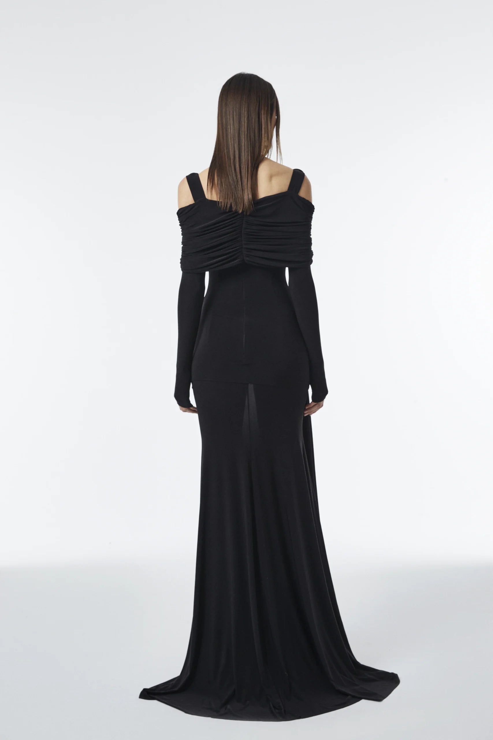 Asymmetric one-strap dress with gold detail, long sleeves, front draping, and side peekaboo cutout.